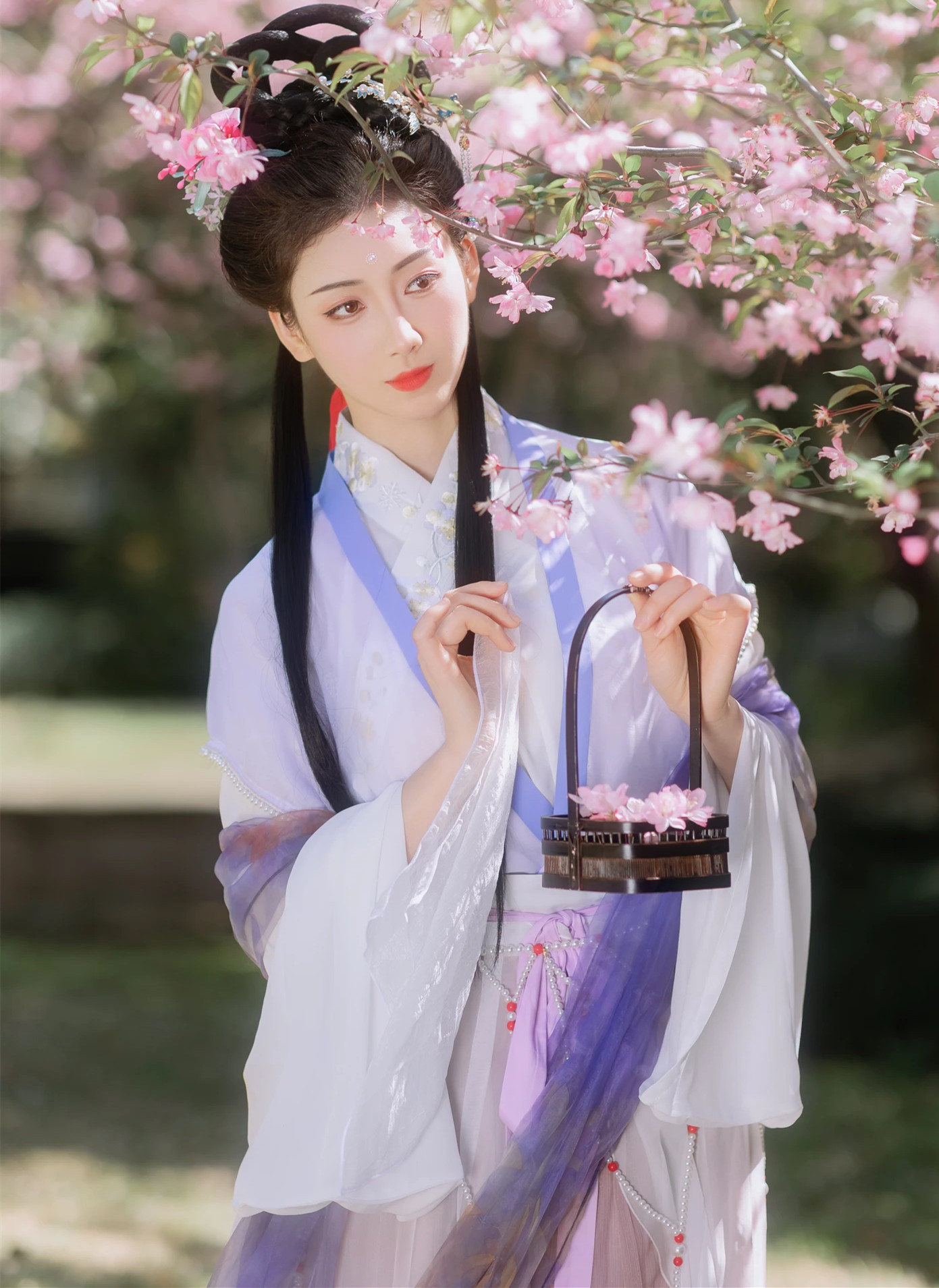 艺图语/艺图语/艺图语镜头下的静姝，身着紫色古装，在樱花飘落的唯美背景中，释放安静系美人的独特韵味！纯真娇嫩的容颜，搭配曼妙身姿的优美曲线。高还原的古风情趣，让你沉醉在古典与浪漫的交织中！